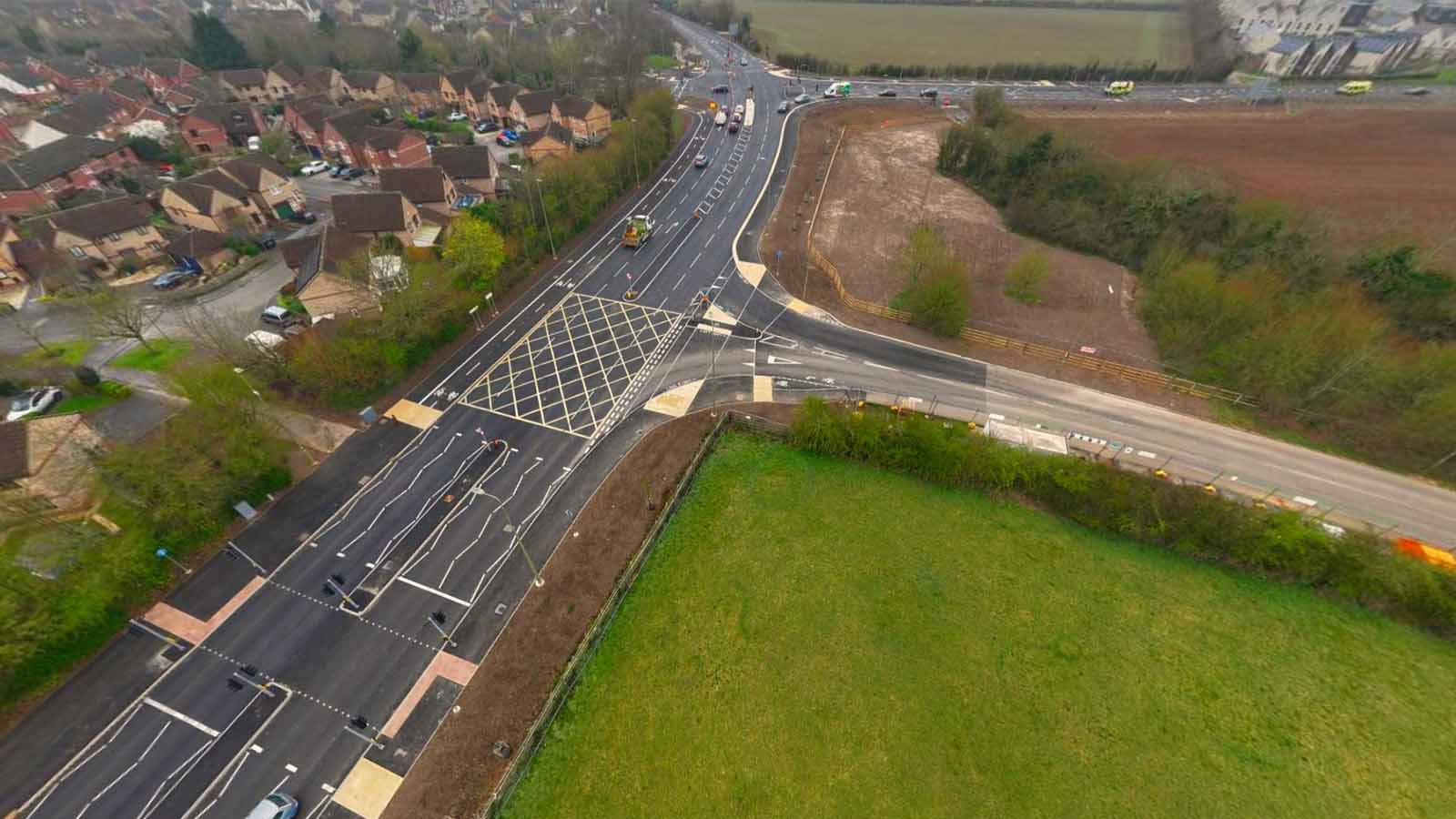 Aerial view of a major road with multiple lanes, traffic lights, box junctions alongside a residential area - Banbury Road, Bicester - Section 278