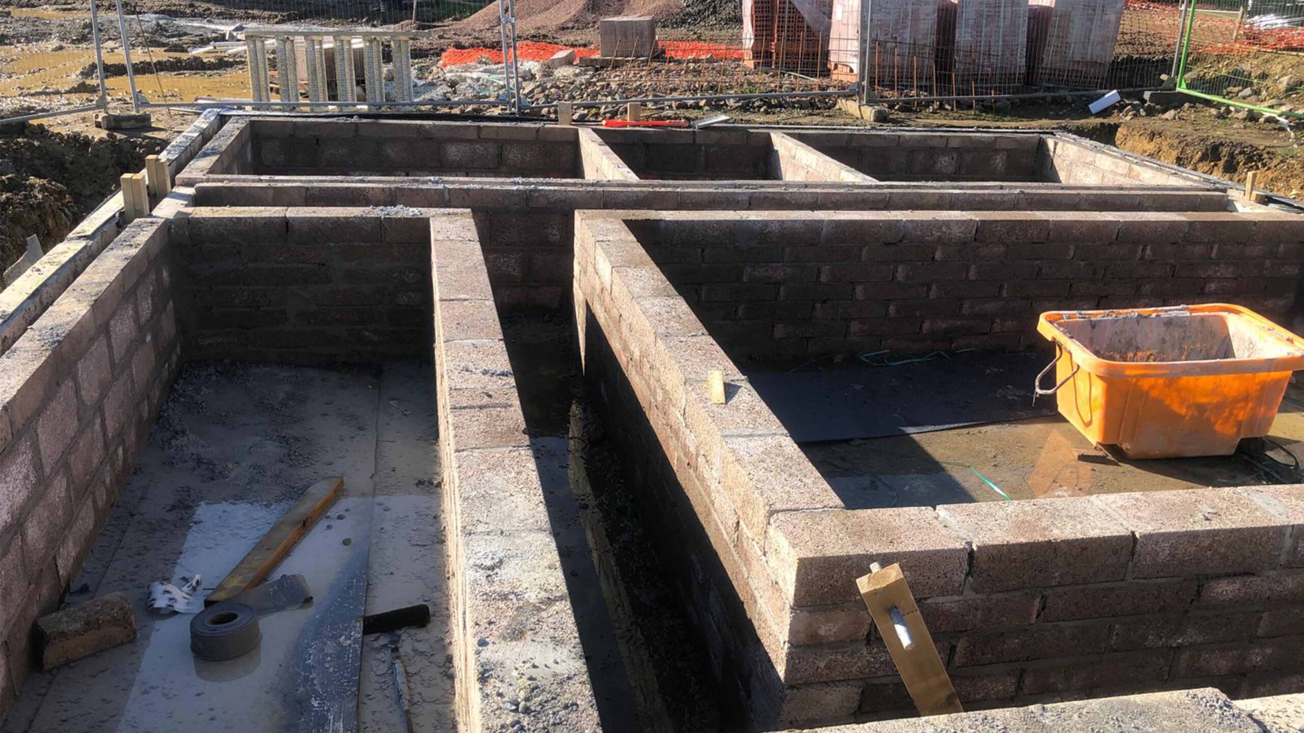 Solar PV Farm Brick foundation walls under construction at a building site, with construction tools and materials visible in the foreground