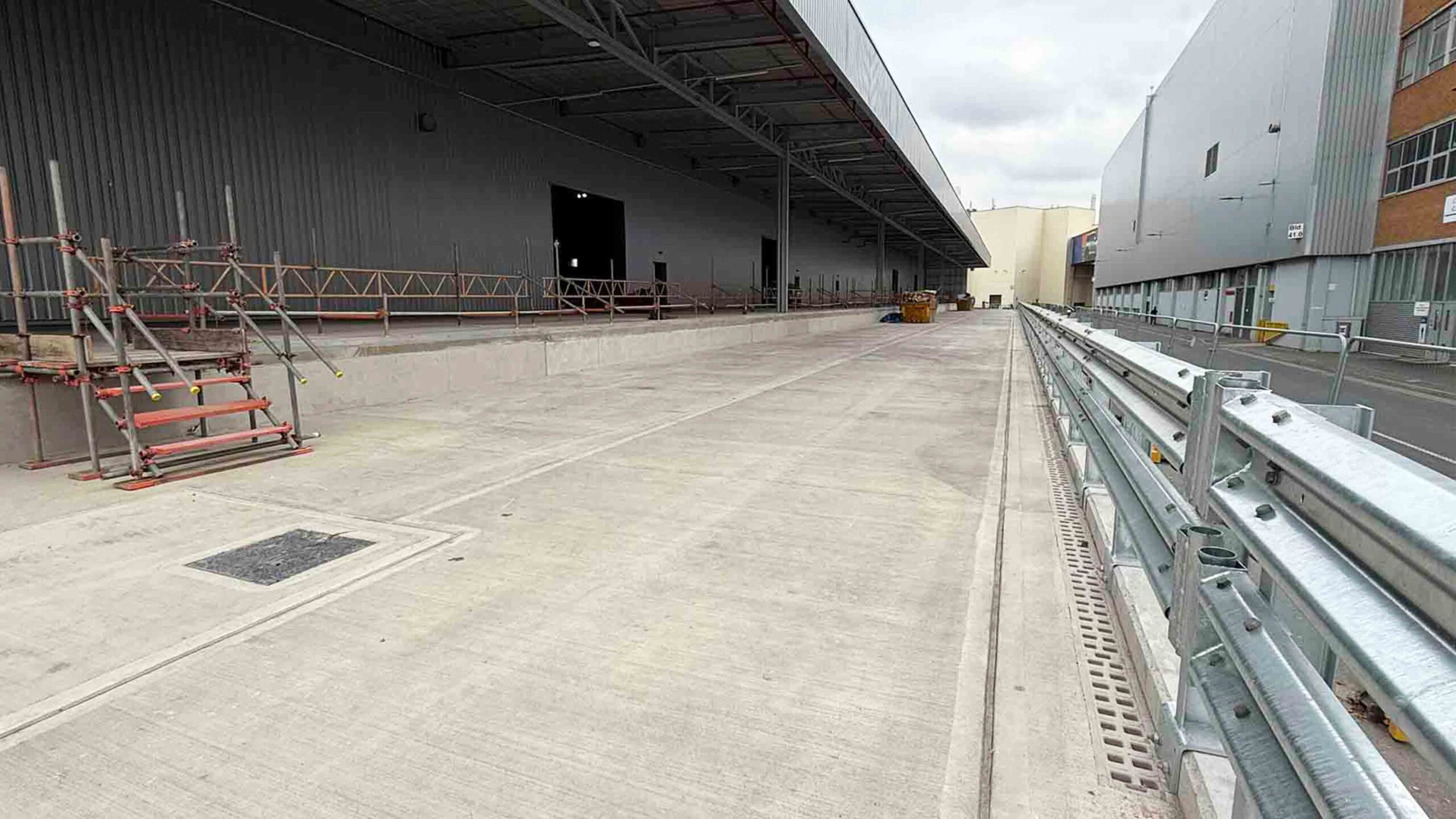 Oxford BMW Warehouse Construction Interior | Natta Interior view of the Oxford BMW construction project showcasing a modern industrial warehouse with steel polished concrete flooring and construction equipment in progress. BMW Mini Plant Oxford - Groundworks Package