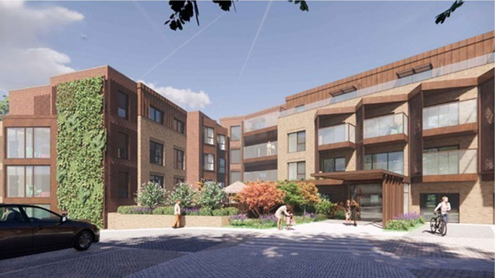 Modern brick apartment complex with a landscaped courtyard and pedestrians, bicycle rider and a parked car visible.